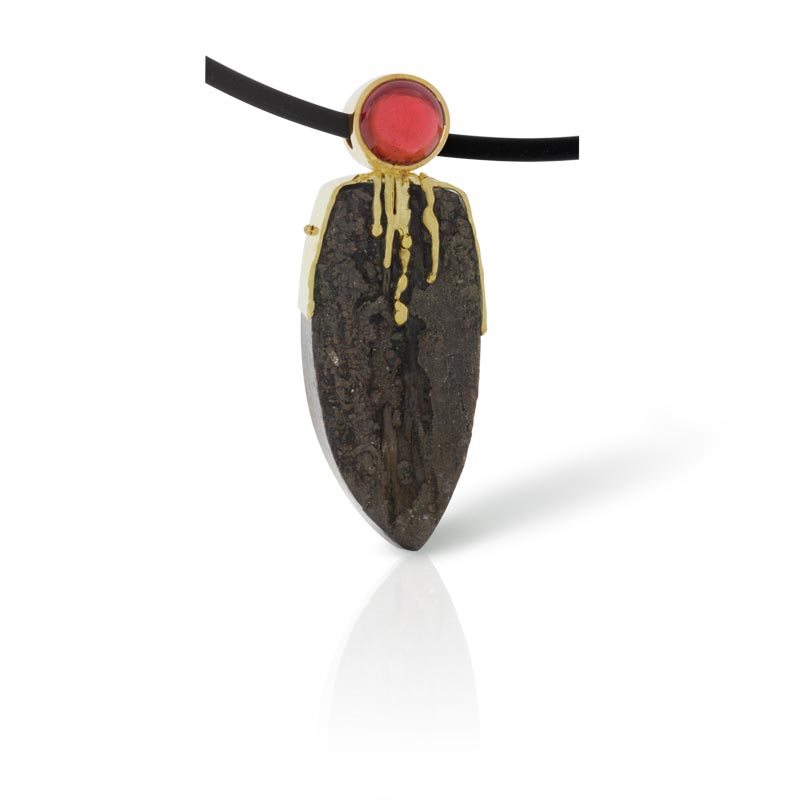 Pendant with petrified wood and a garnet in gold